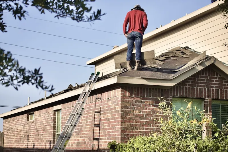 Professional roofer working on a residential roof in Cushetunk